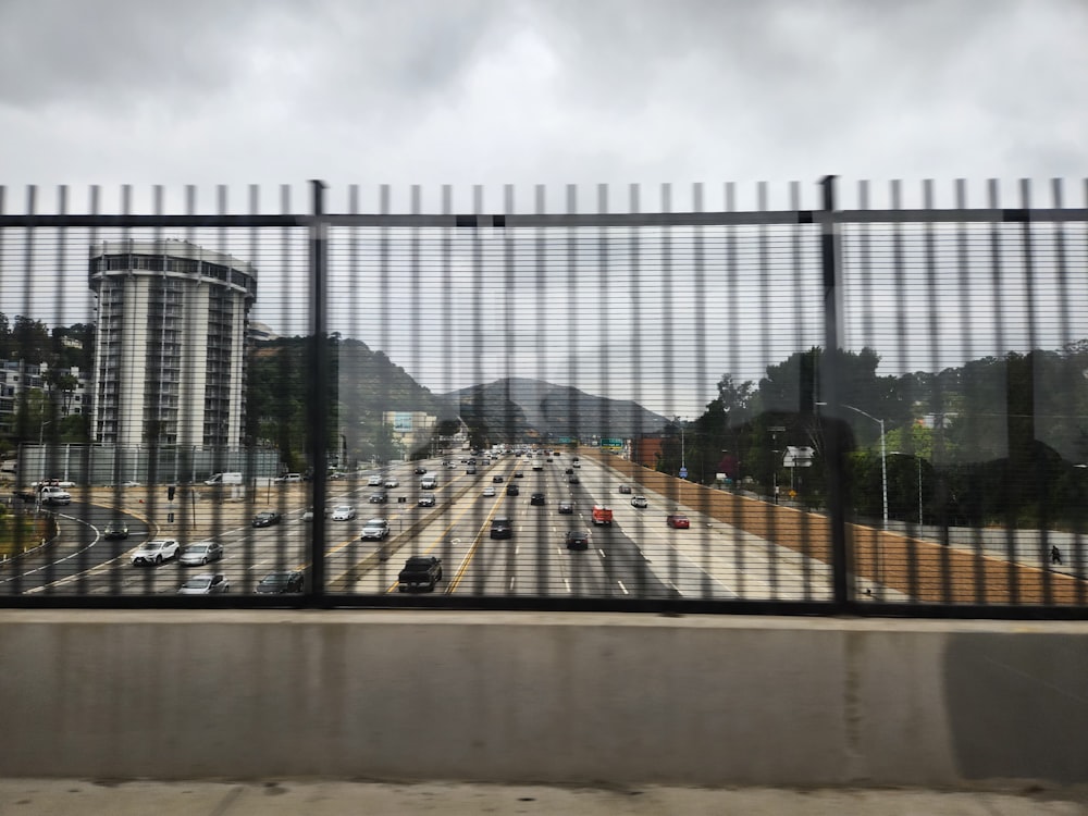 a view of a highway through a fence