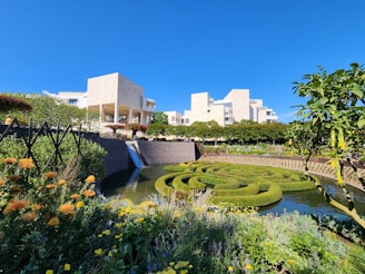 a garden with a pond surrounded by flowers