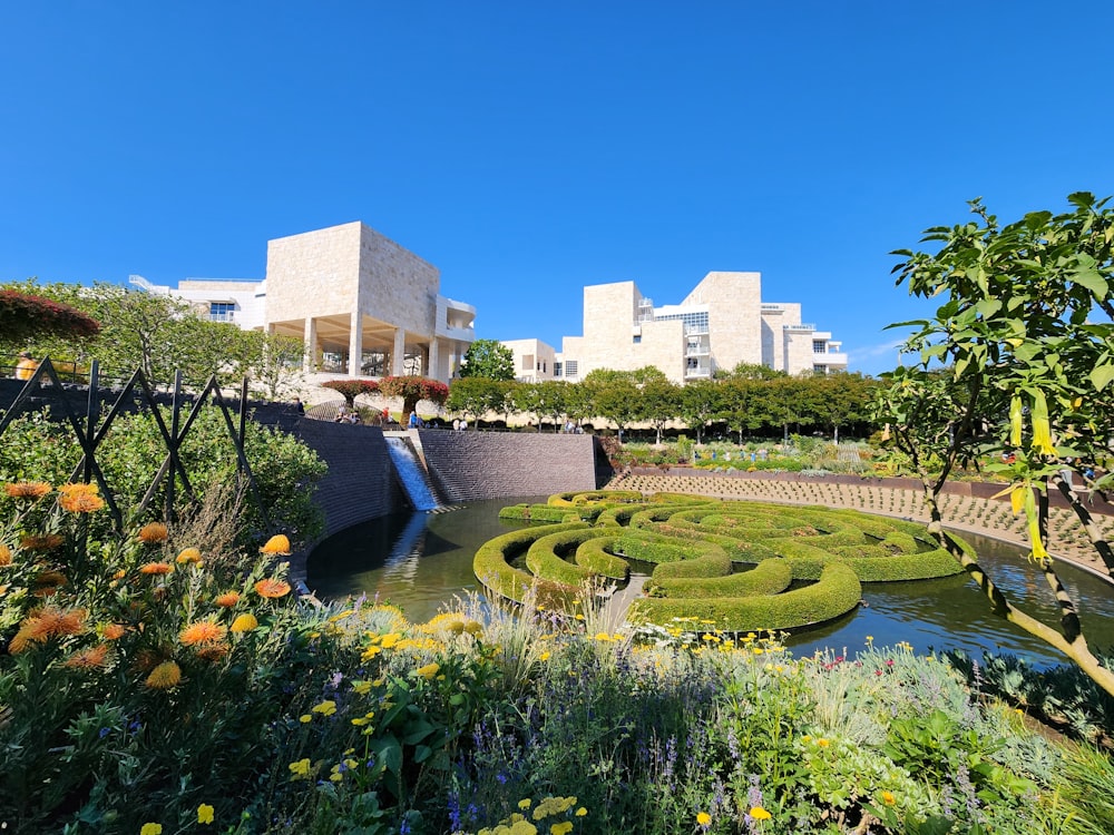 a garden with a pond surrounded by flowers