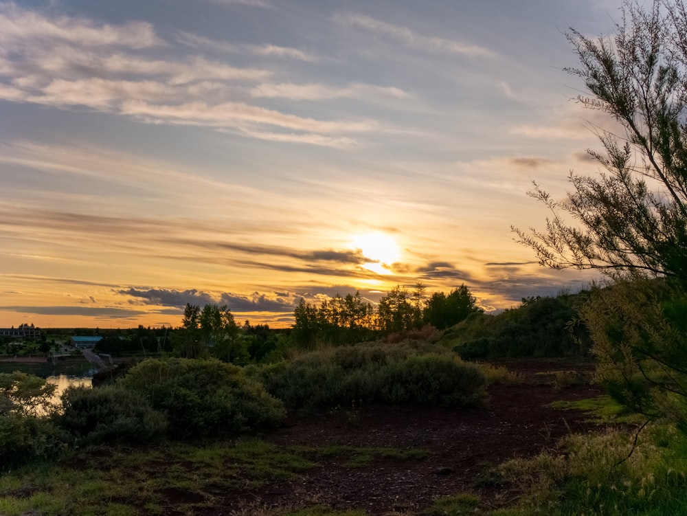 the sun is setting over a small river