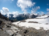 A panoramic view of snow-capped peaks with a winding trail below.