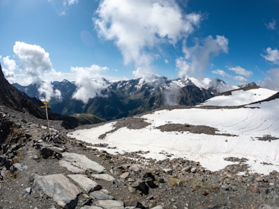 A panoramic view of snow-capped peaks with a winding trail below.