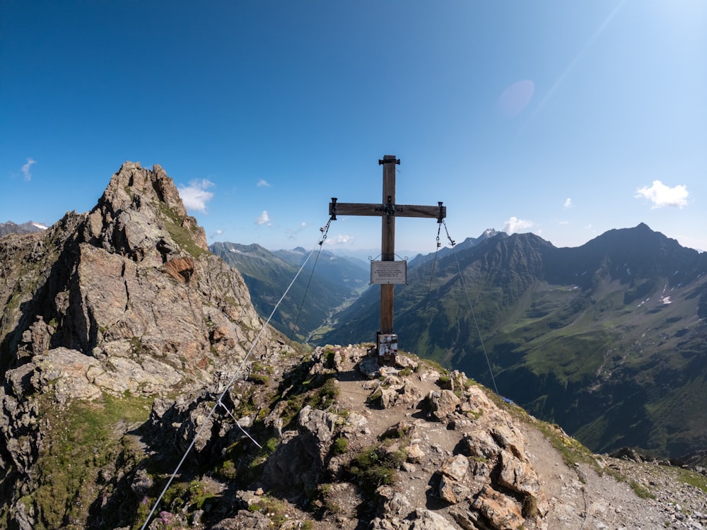 a cross on top of a mountain with mountains in the background