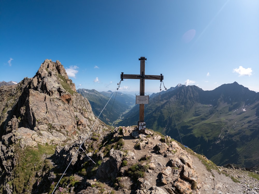 une croix au sommet d’une montagne avec des montagnes en arrière-plan