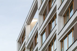 a tall building with lots of windows next to a sky background