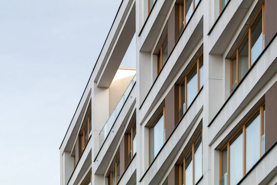 a tall building with lots of windows next to a sky background