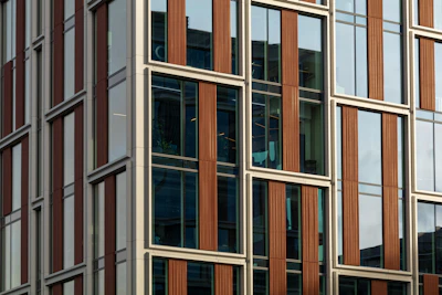 Modern building facade with sunlight highlighting its structural details.
