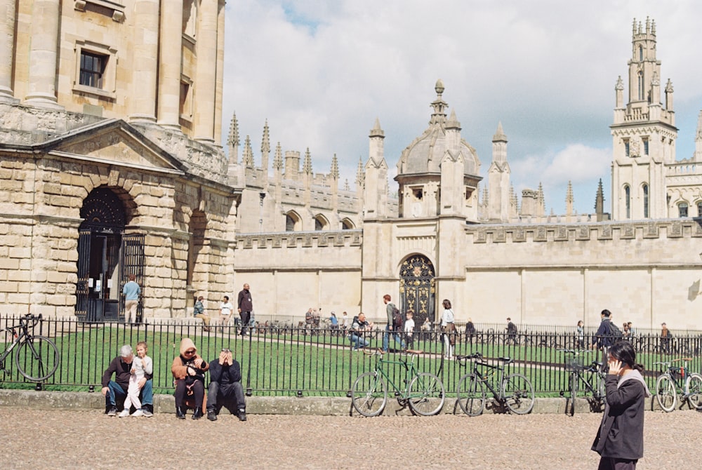 a group of people sitting and standing in front of a building