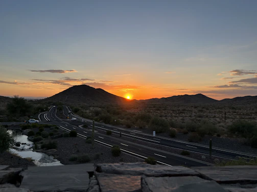 A serene desert landscape at sunset with a winding road leading into Death Valley.
