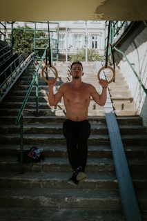 A fit middle-aged man exercising outdoors with a city skyline in the background.