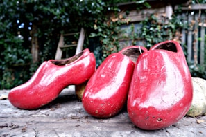 A pair of sturdy, stylish clogs displayed on a rustic wooden floor.