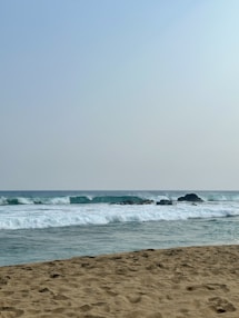 a person walking on the beach with a surfboard