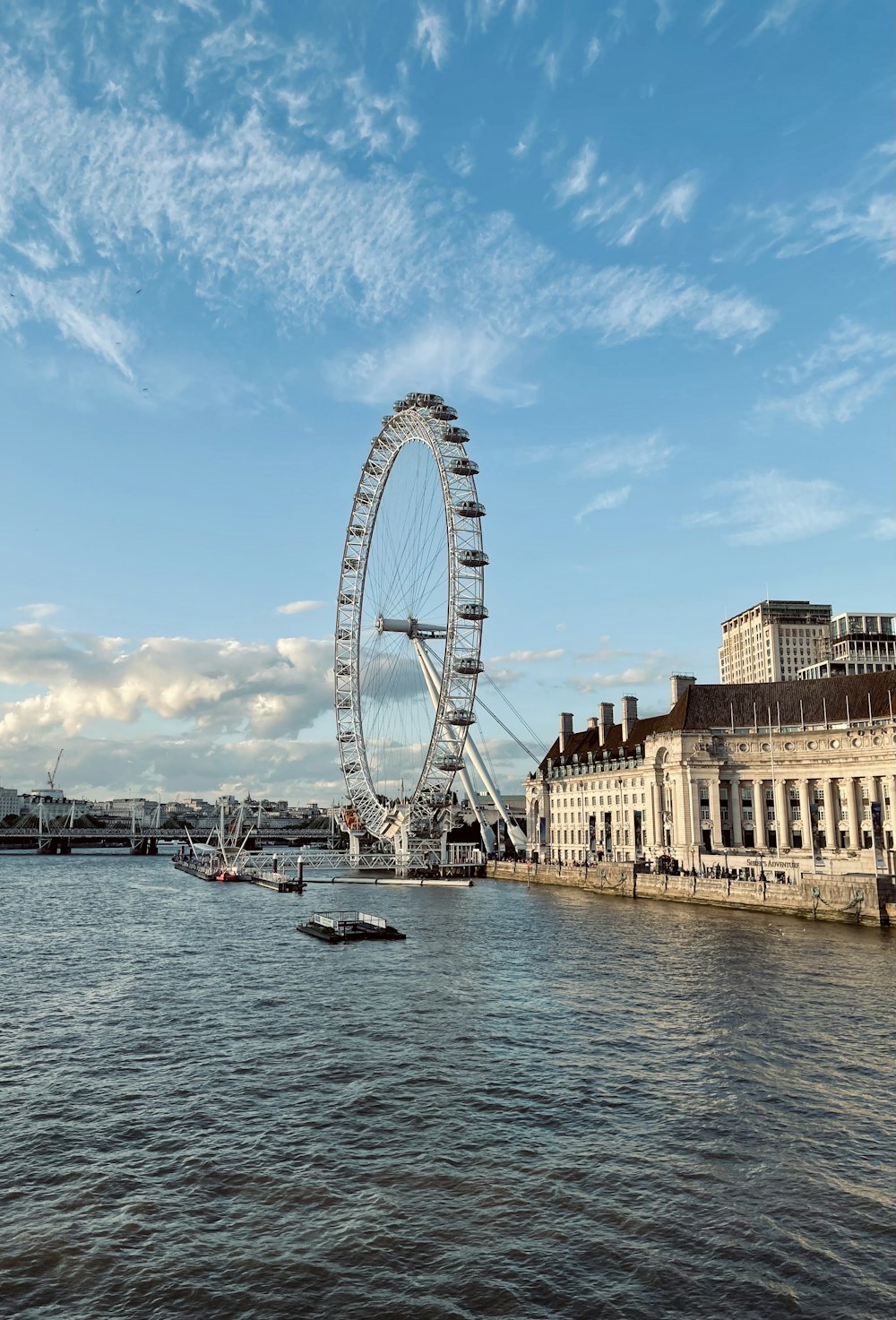 a large ferris wheel on the side of a river