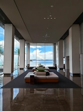 Stylish resort lobby with open-air design, tropical plants, and inviting seating areas.