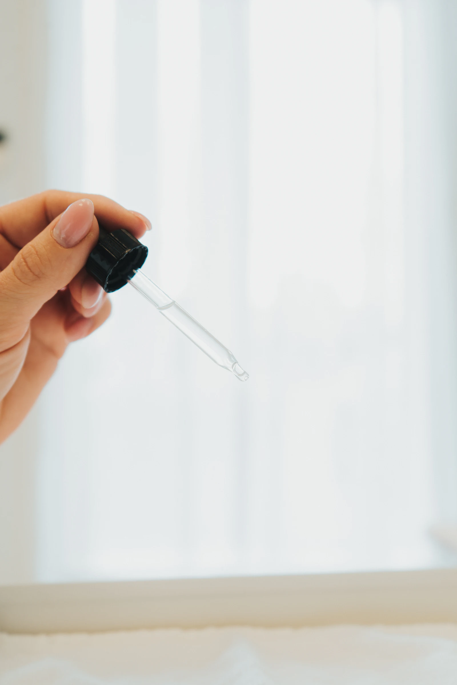 Pipette mit Wirkstoffserum im weichen Fensterlicht des Behandlungsraums