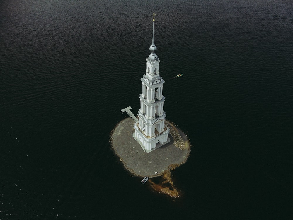 an aerial view of a church tower in the middle of the water