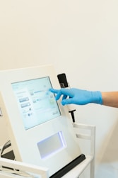 a person in blue gloves is operating a machine