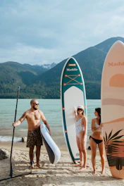 a group of people standing on a beach next to surfboards