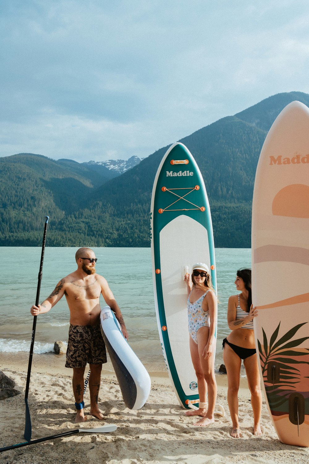 a group of people standing on a beach next to surfboards