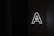 A large, glowing letter 'A' with a stylized arrow pointing upwards inside it is placed against a dark background, emitting bright white light.