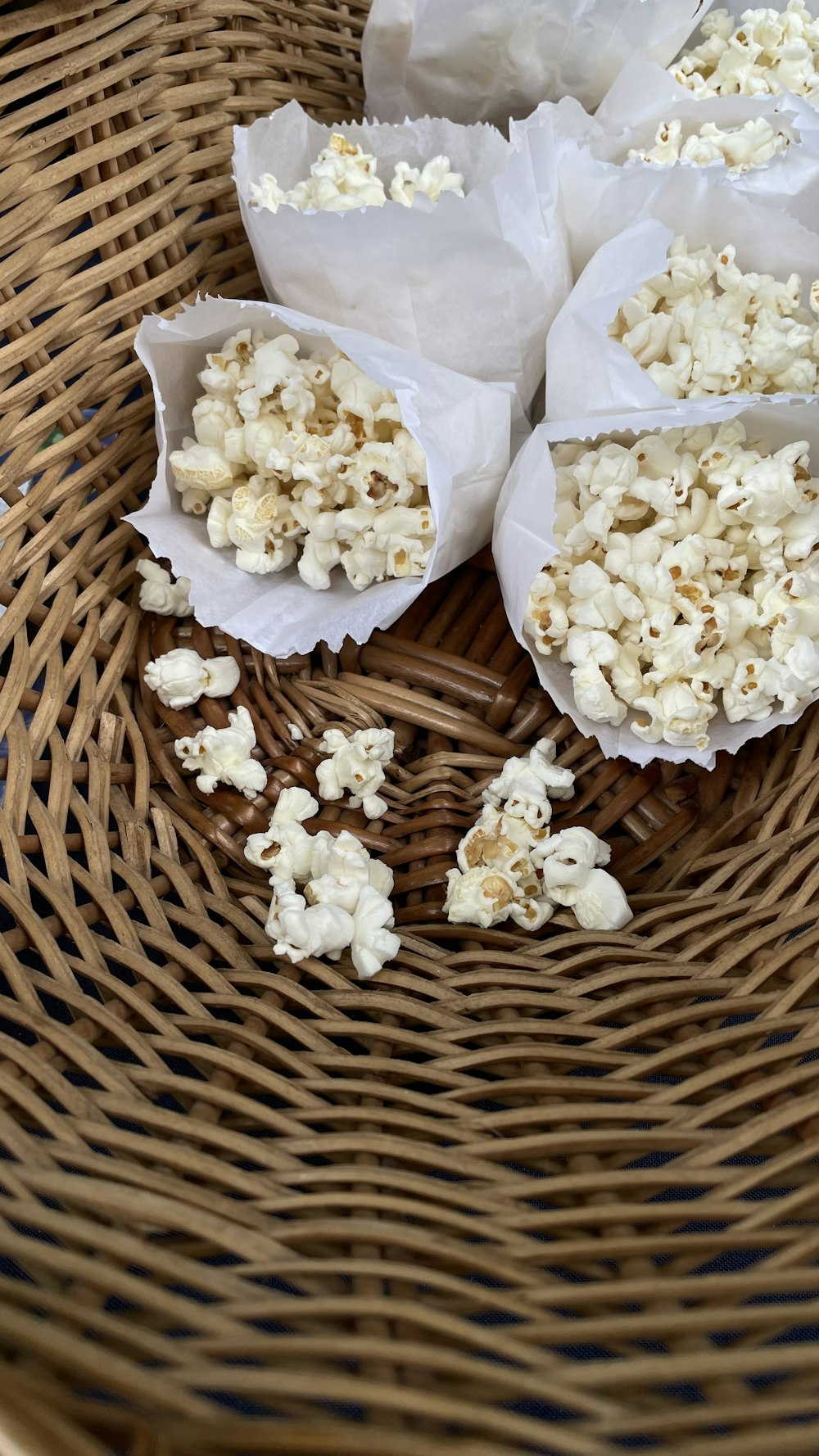 three bags of popcorn sitting on top of a wicker basket