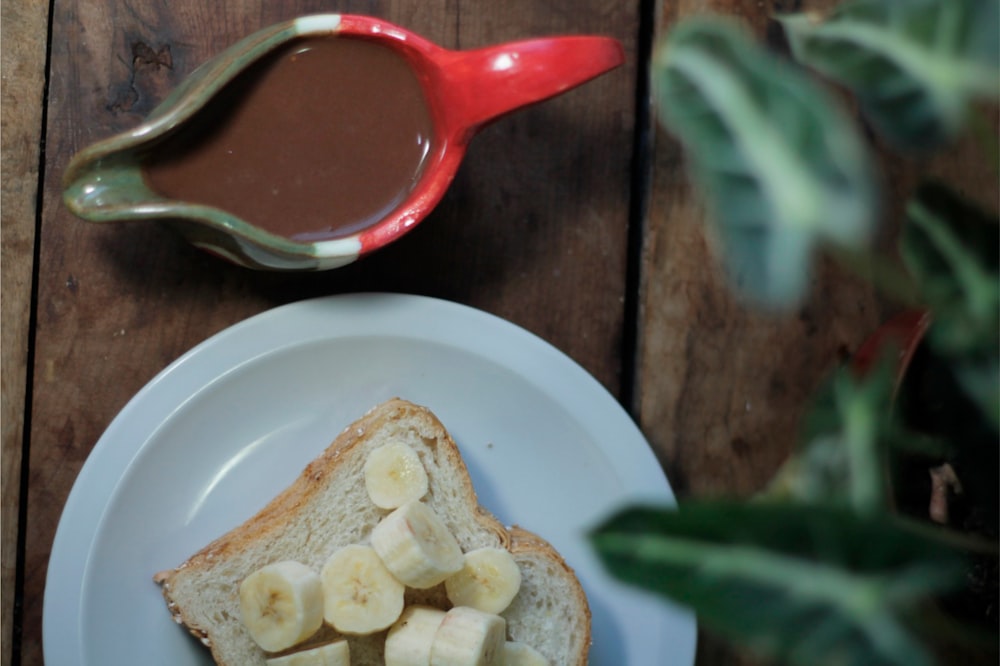 a plate with a piece of bread and some bananas on it