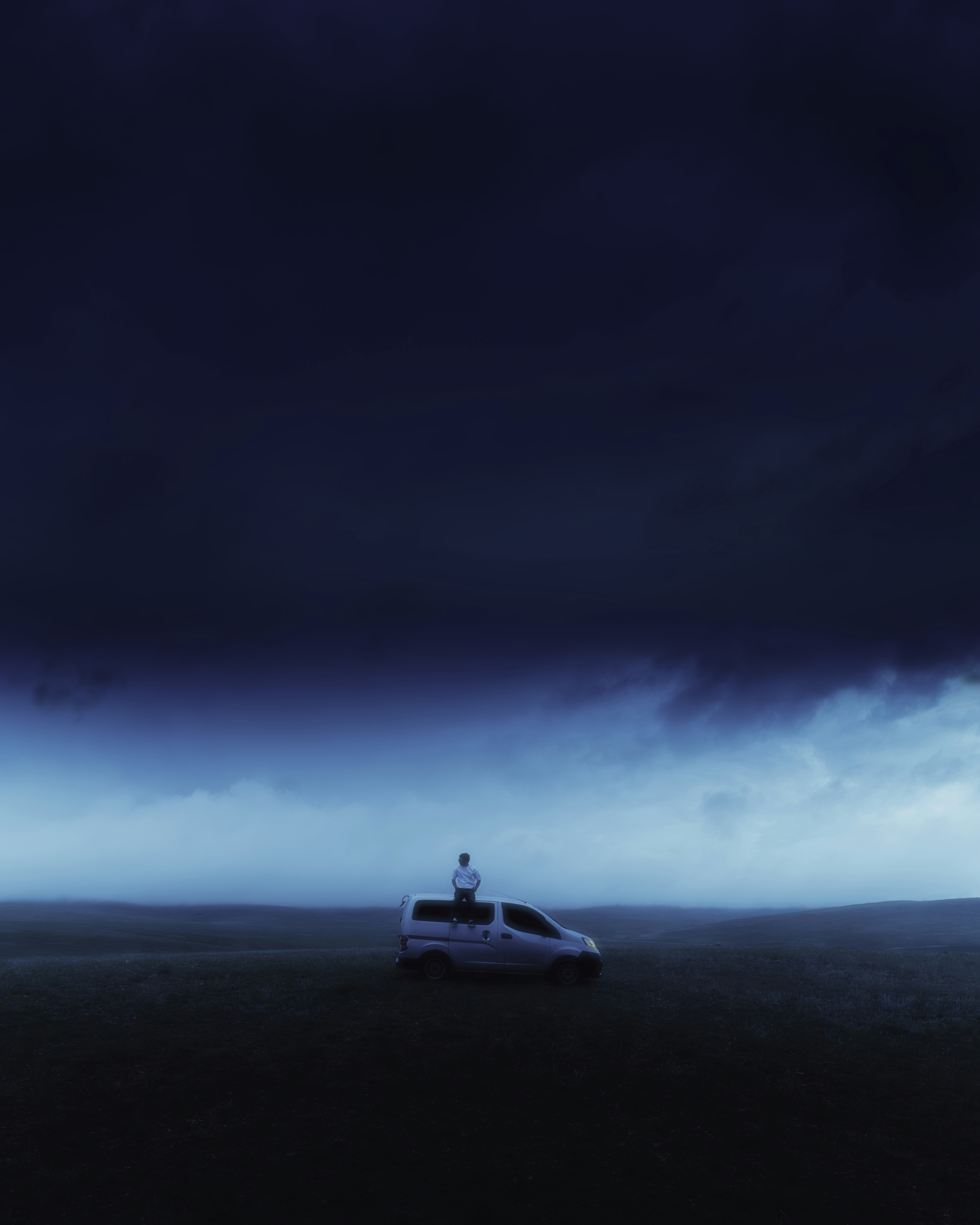 a car parked in a field under a dark sky
