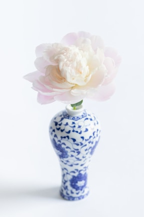 Close-up of a delicate porcelain vase with intricate floral patterns in soft pastel colors.