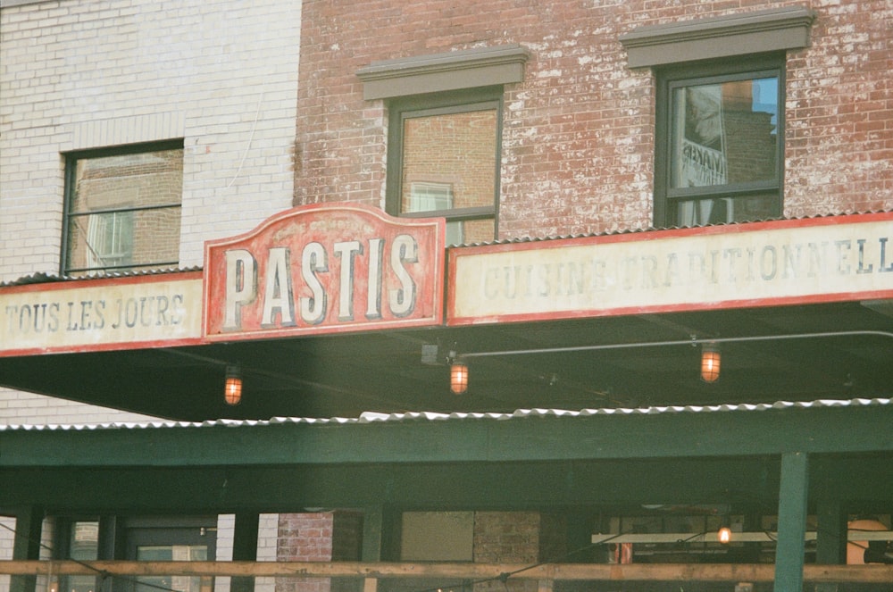 a sign that reads pastis outside of a building