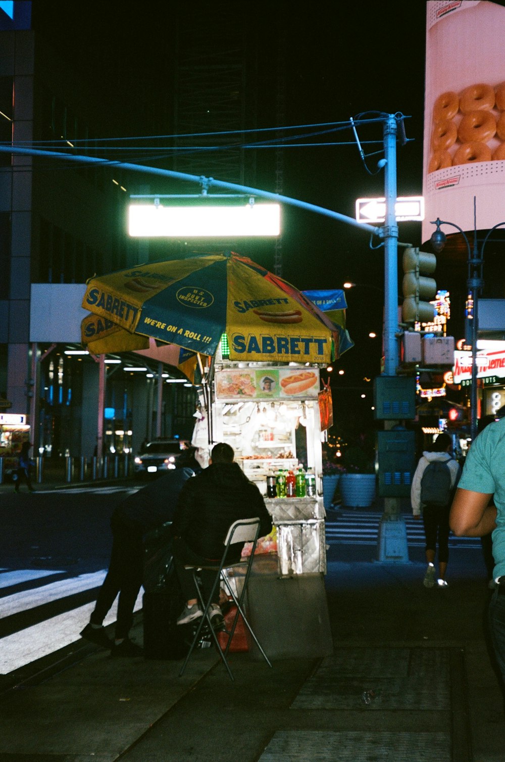 a couple of people sitting at a food stand