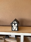 A wooden birdhouse kit displayed on a table.