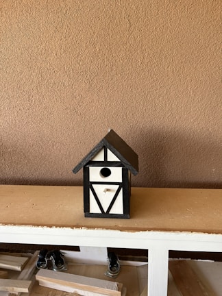 A wooden birdhouse kit displayed on a table.