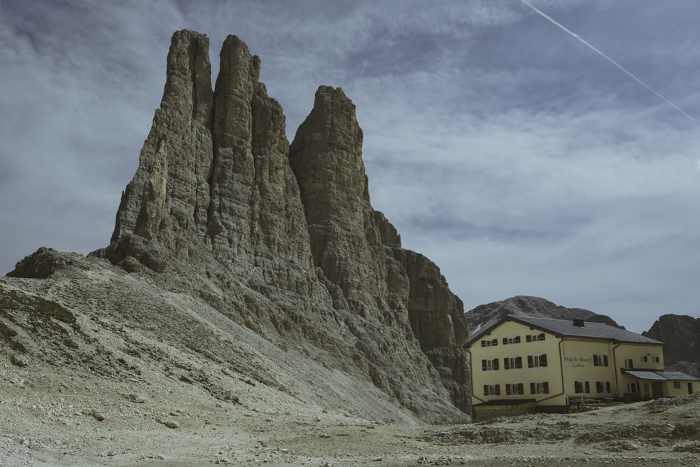 a house in the middle of a desert with a mountain in the background