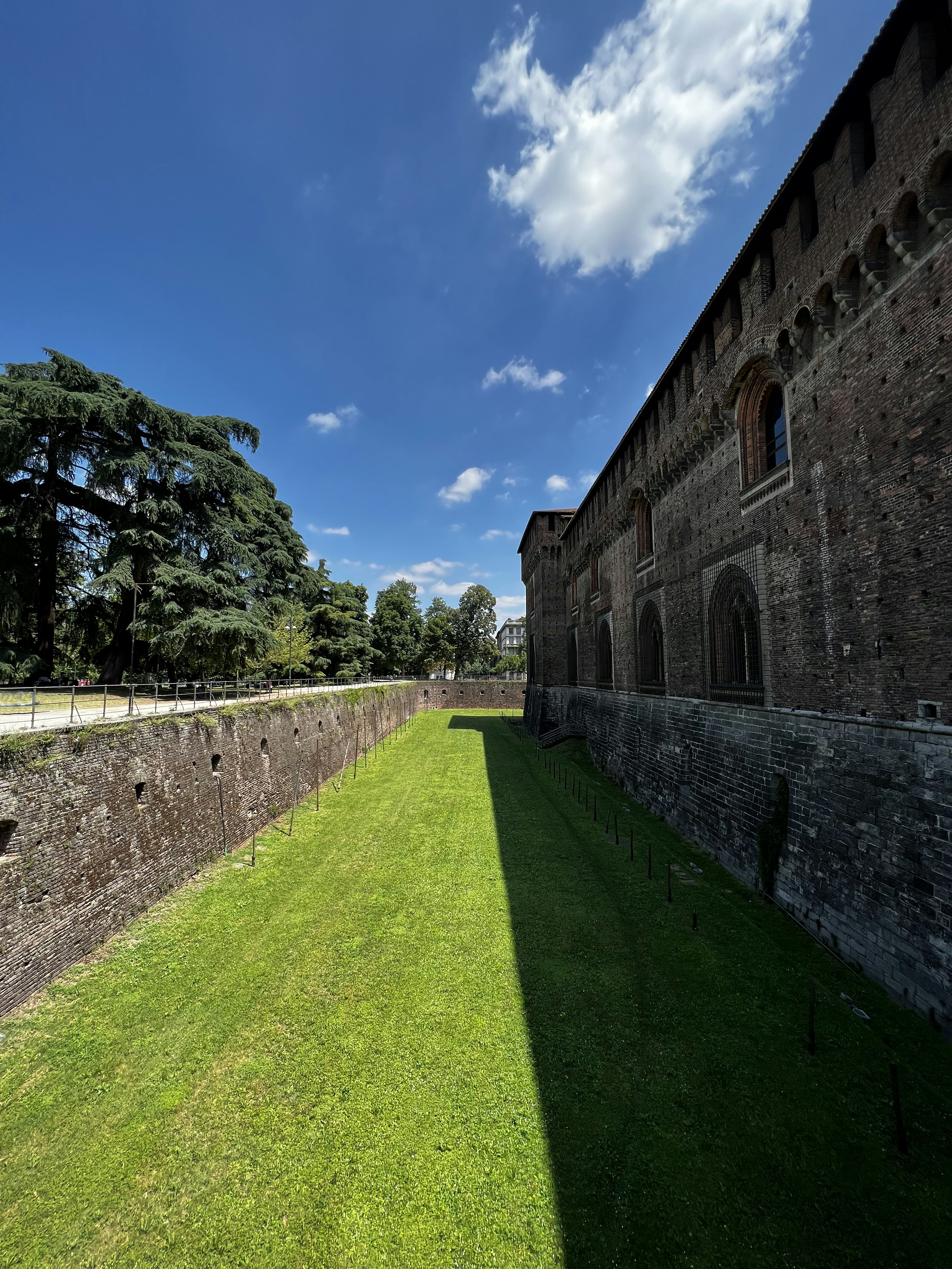 um grande campo gramado ao lado de um edifício de pedra