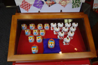 An elegant display case filled with tiny sculptures and paintings from the 1960s.
