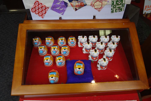 An elegant display case filled with tiny sculptures and paintings from the 1960s.