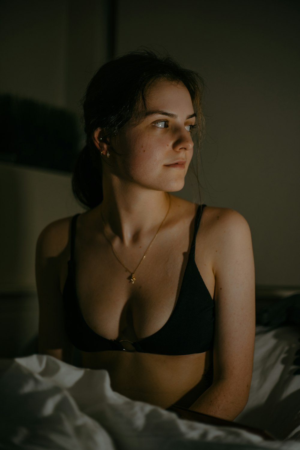 A woman in a bra top sitting on a bed photo – Free Female Image on