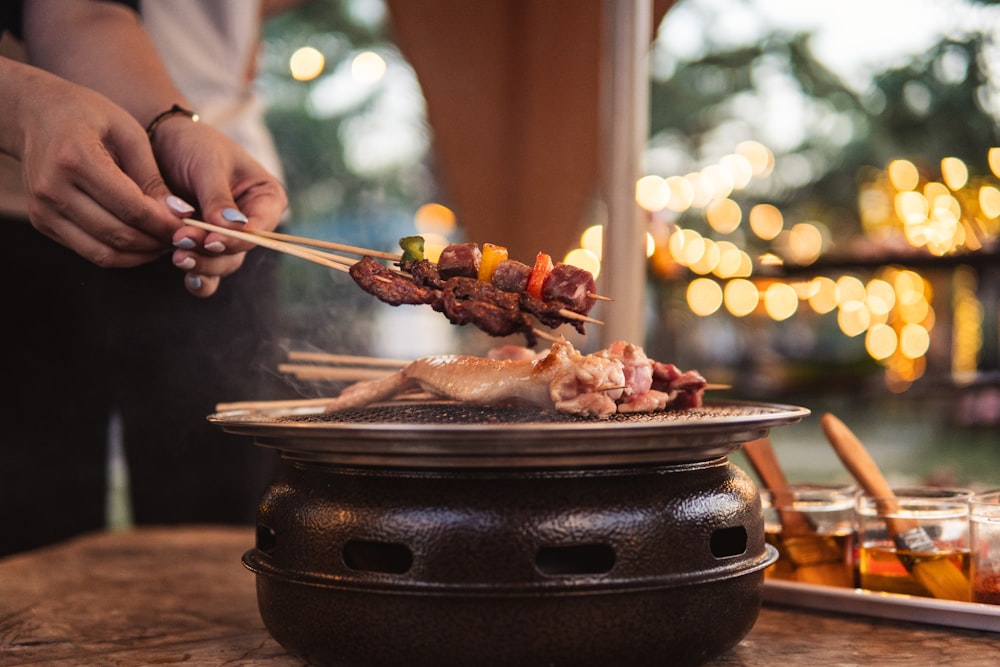 a person holding chopsticks over a bowl of food