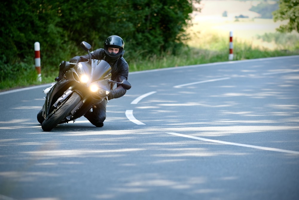 a man riding a motorcycle down a curvy road