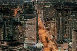 A bustling cityscape at night with bright lights.