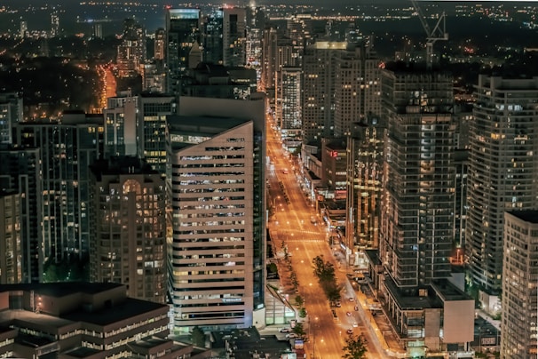 A bustling cityscape at night with bright lights.
