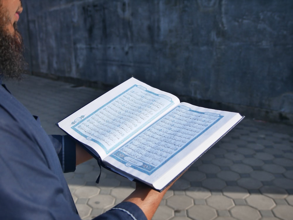 Un hombre sosteniendo un libro abierto con números en él