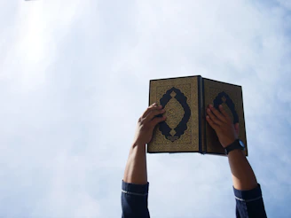 Close-up portrait of a happy traveler holding a prayer book on a sunny day.