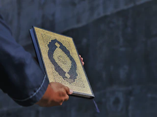 Close-up of hands holding a premium e-book with dark and gold design elements.