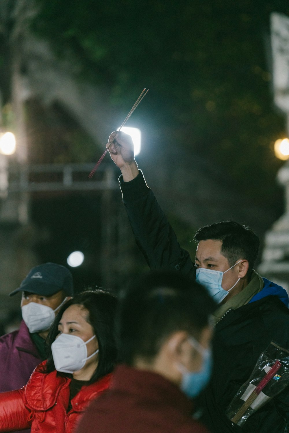 a group of people wearing face masks standing in a crowd