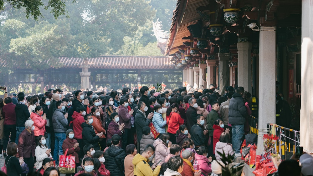 a large group of people standing outside of a building