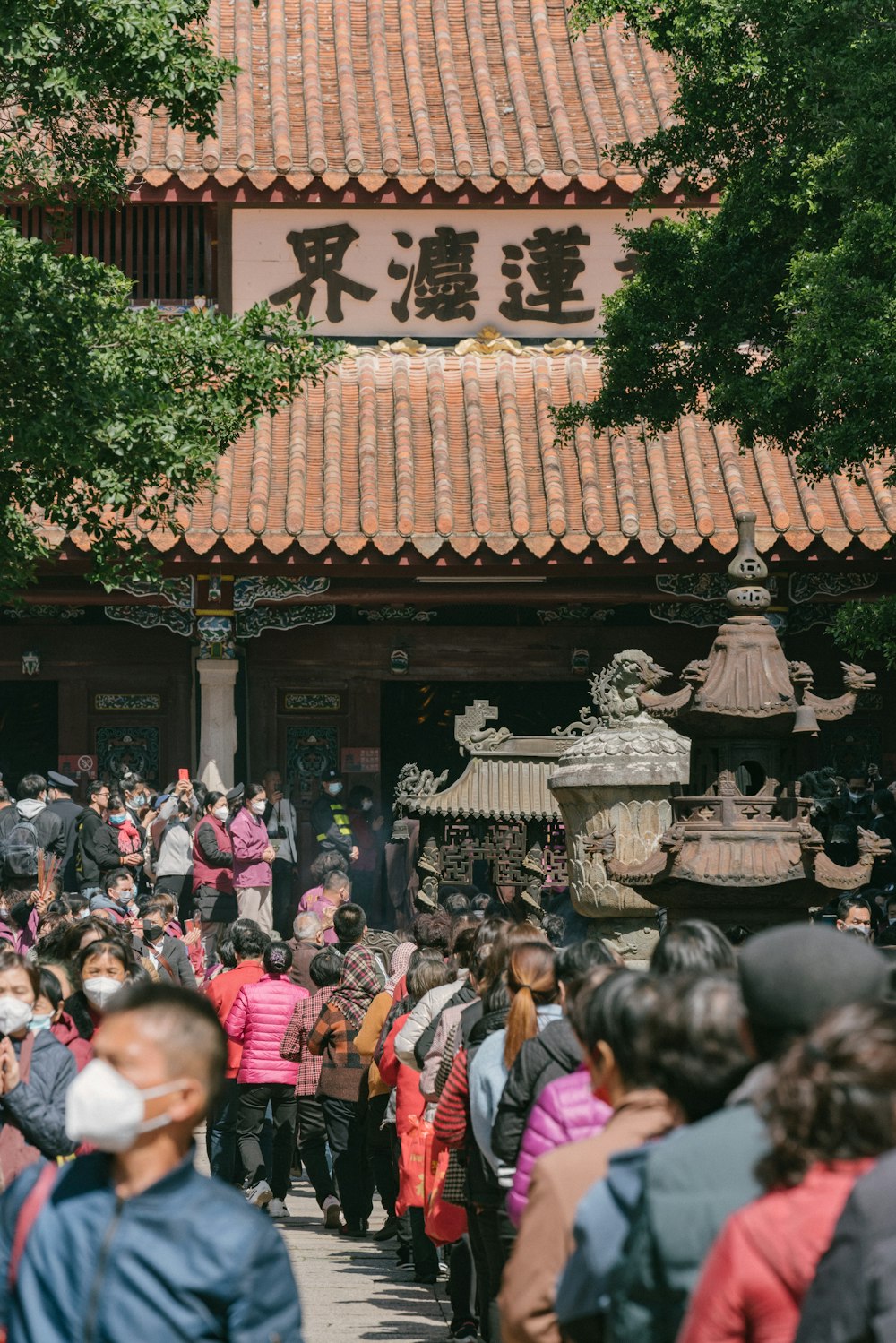 a crowd of people walking down a street next to a building