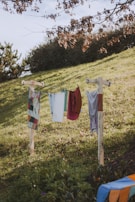 Brightly colored summer dresses hanging on a rustic clothesline swaying gently in the breeze.