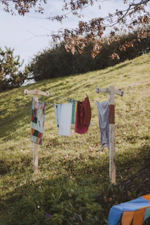 A vibrant display of colorful custom clothing hanging on a rustic clothesline outdoors
