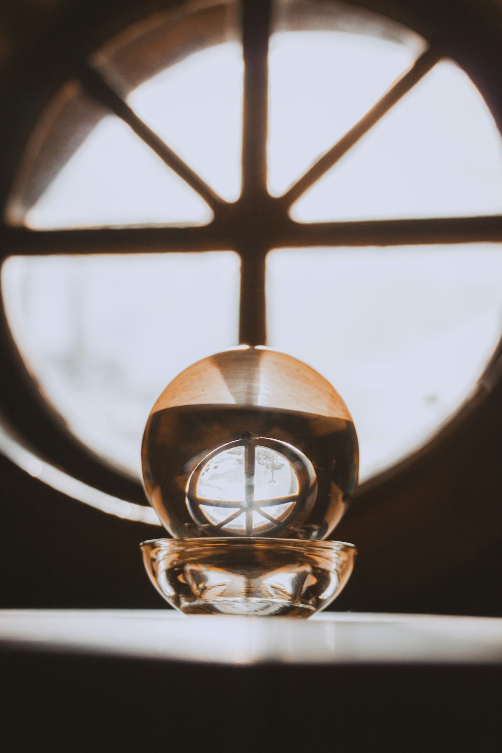 a glass vase sitting in front of a window